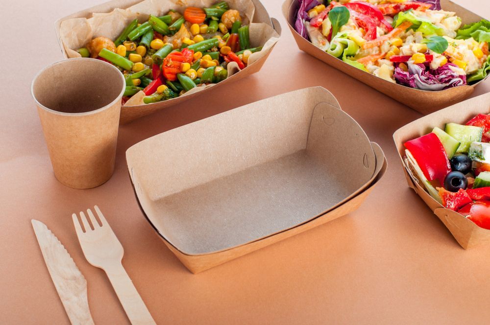 A Table Topped With Trays Of Food And Utensils — Home Nursing Services In Cardiff, NSW