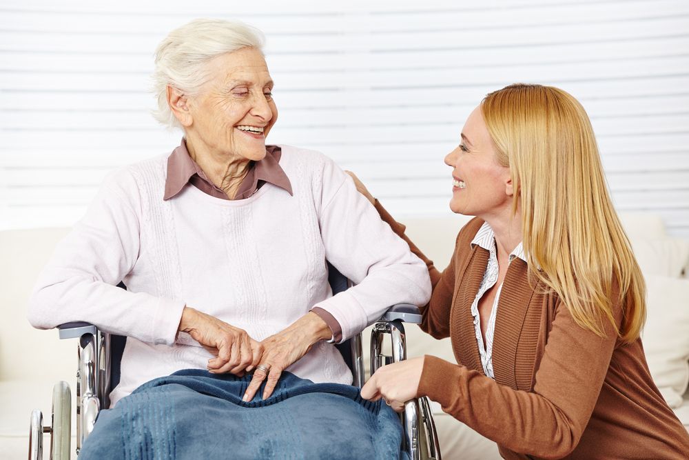 A Woman Is Talking To An Elderly Woman In A Wheelchair — Home Nursing Services In Toronto, NSW