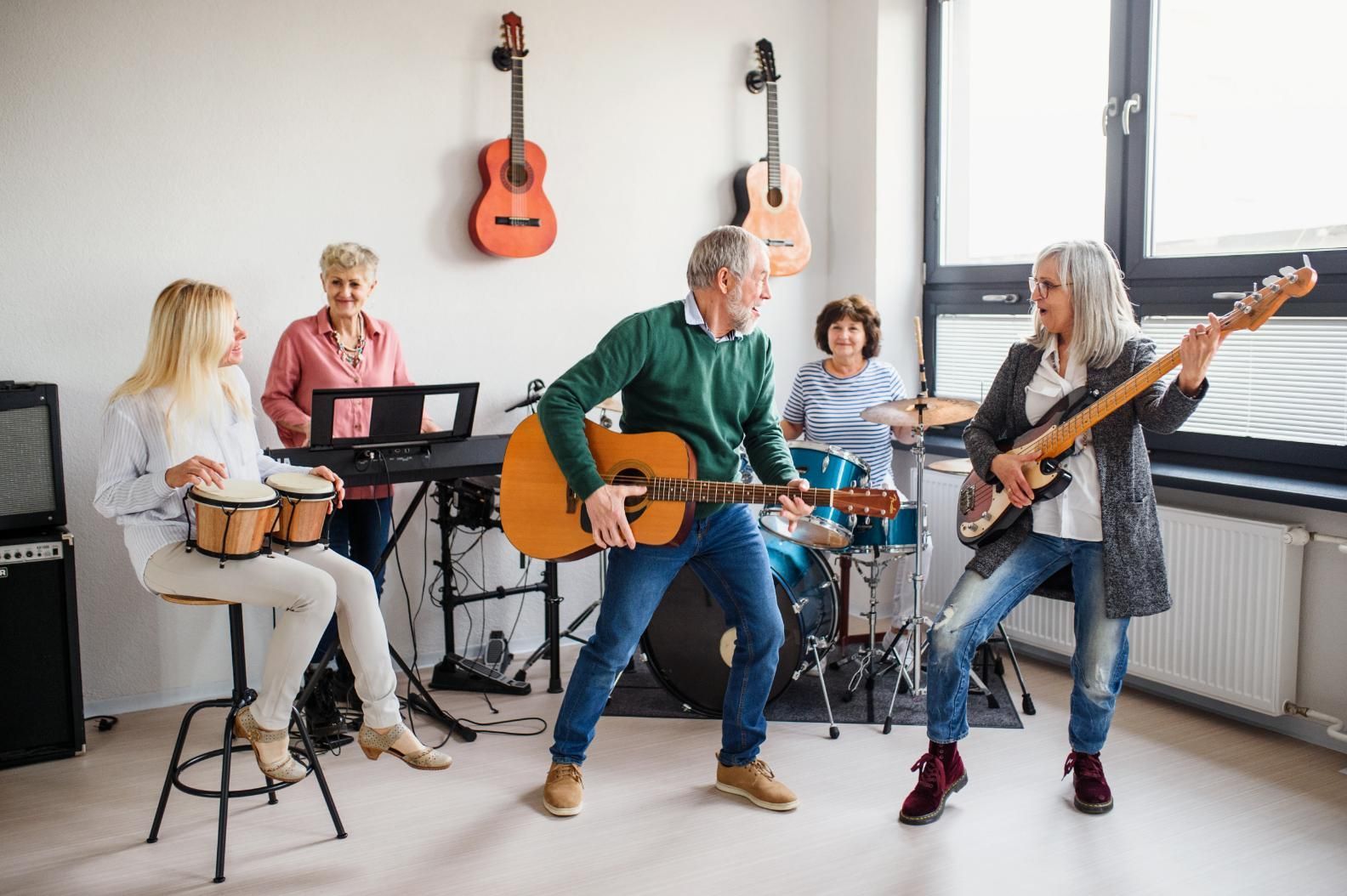 A Group Of People Are Playing Guitars And Drums In A Room — Home Nursing Services In Kew, NSW