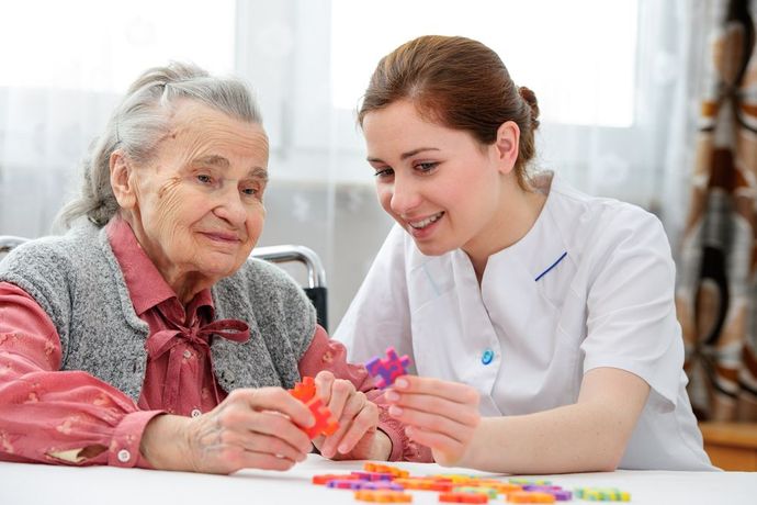 A Nurse is Helping an Elderly Woman With a Puzzle — Home Nursing Services In Macquarie, NSW