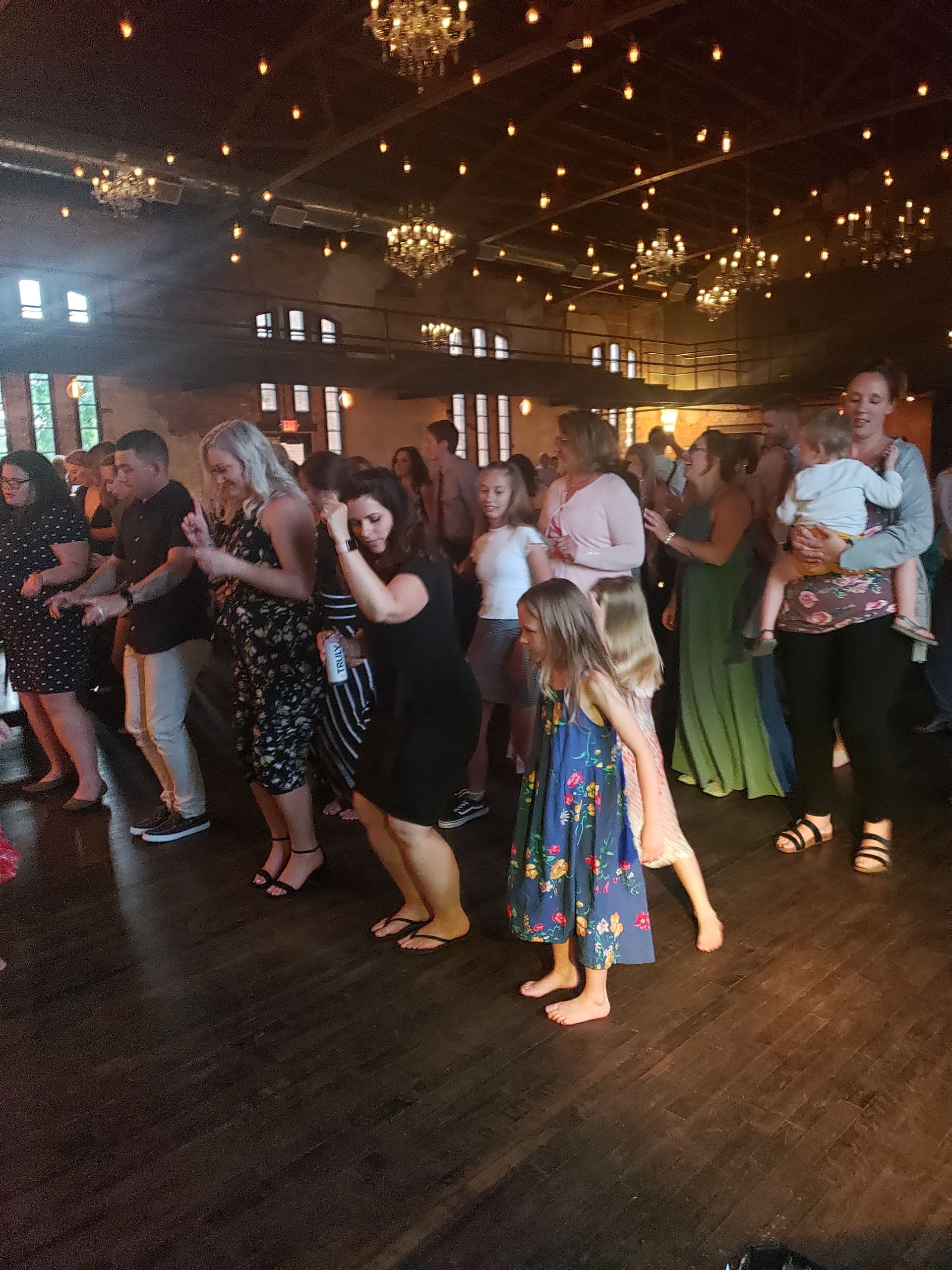 A large group of people are dancing in a large room.