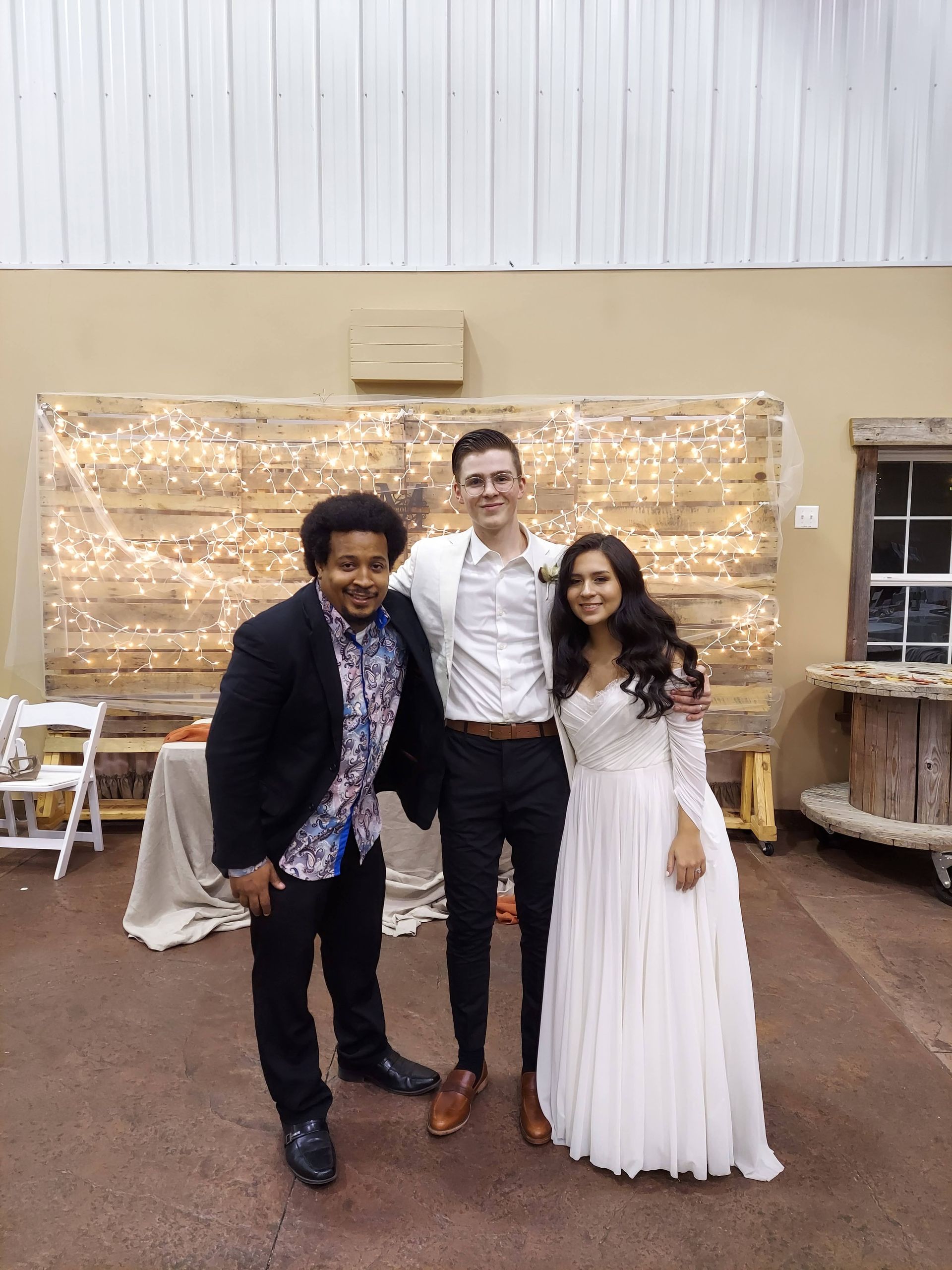 A bride and groom are posing for a picture with two men.