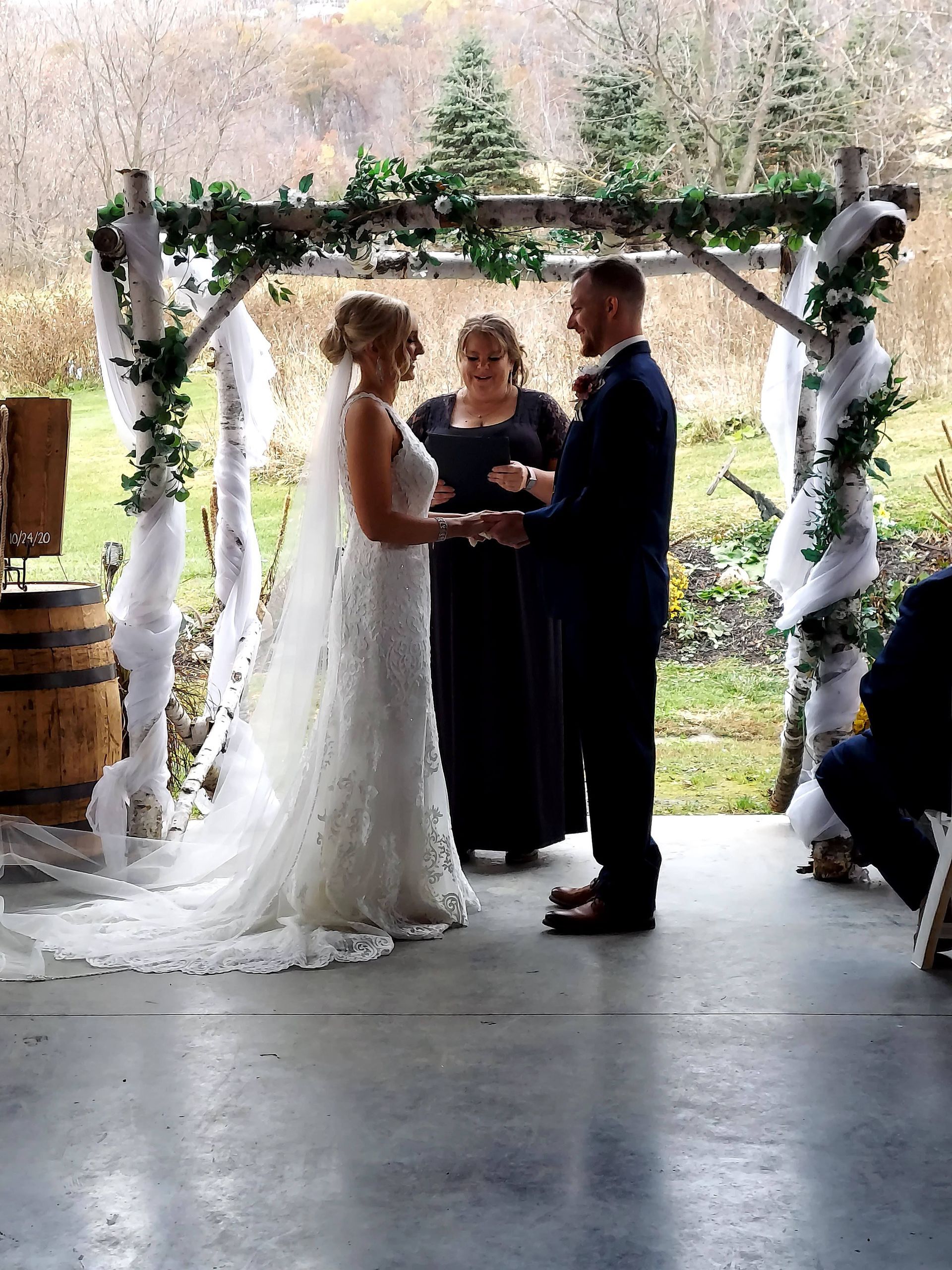 A bride and groom are holding hands during their wedding ceremony.