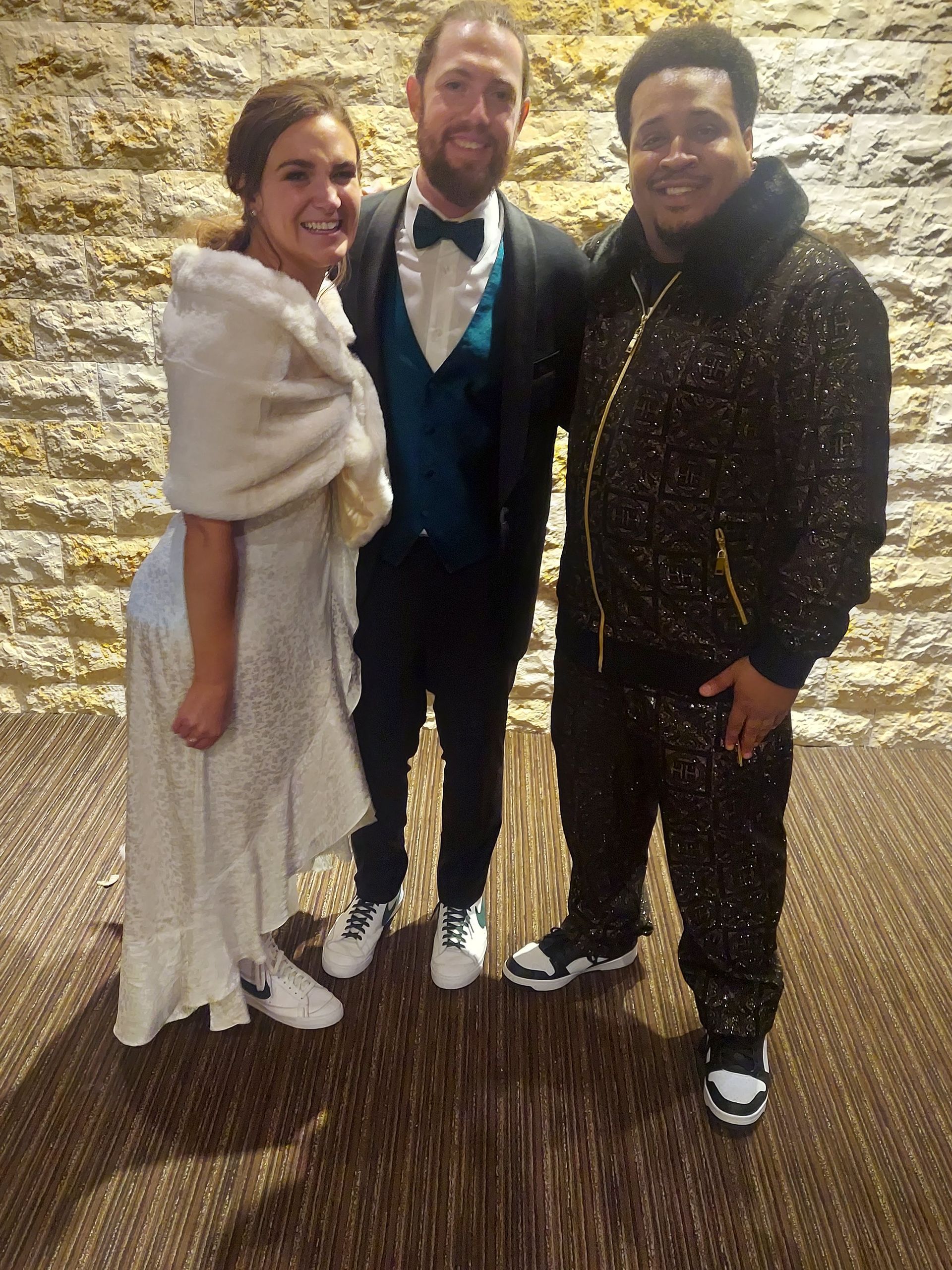 A bride and groom are posing for a picture with two men.
