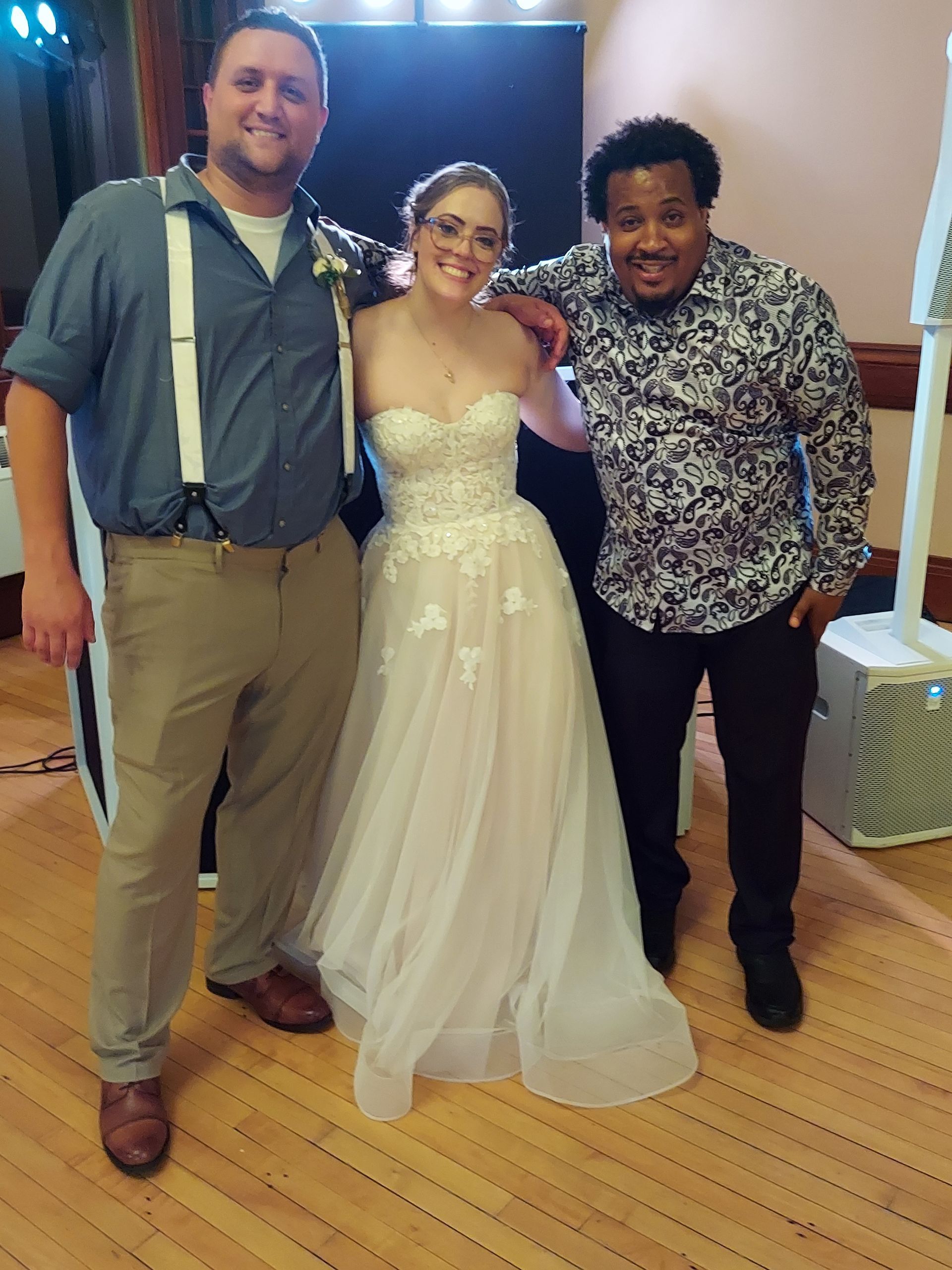 A bride and groom are posing for a picture with two men.