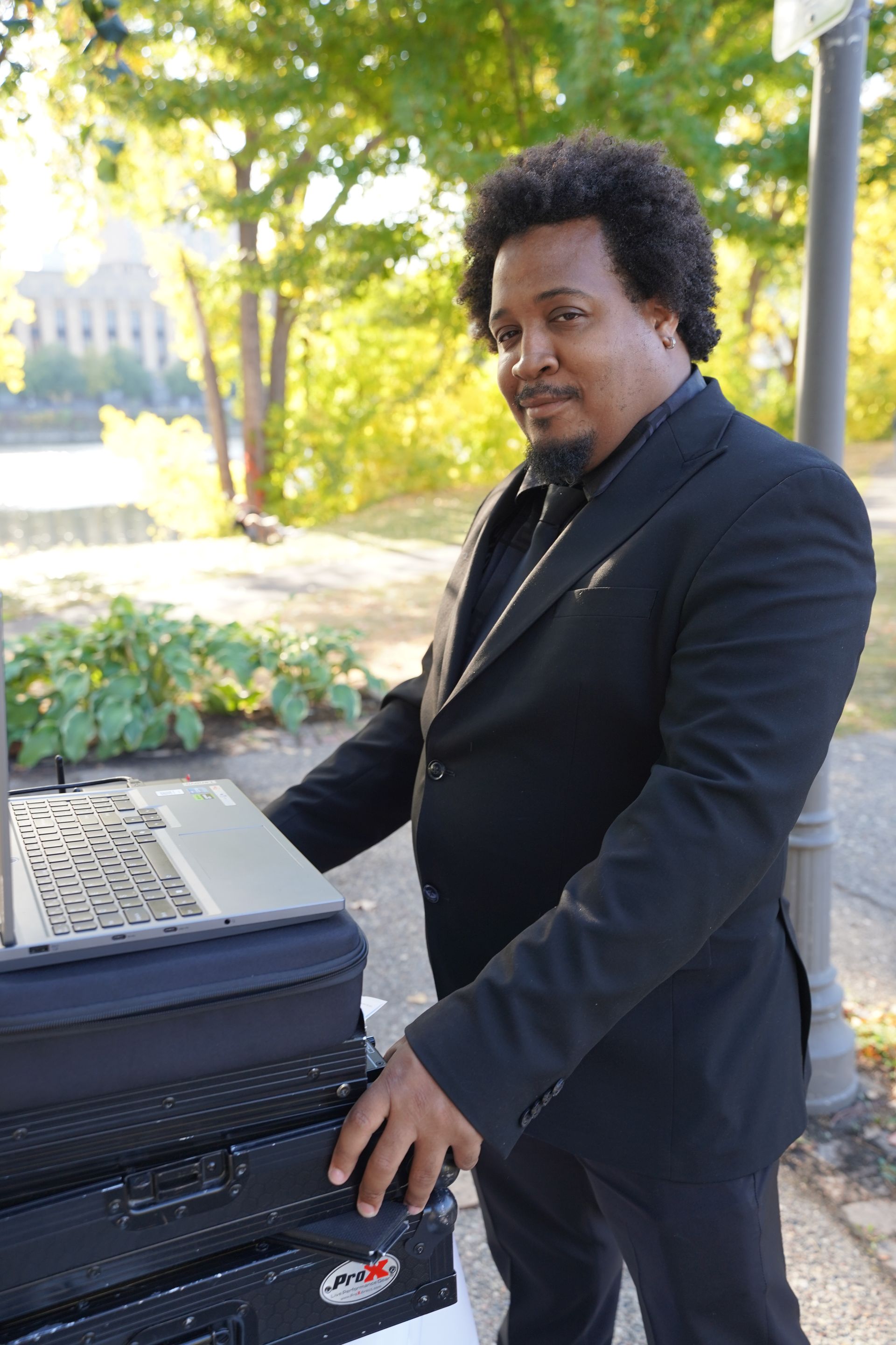 A man in a suit is standing next to a stack of keyboards.