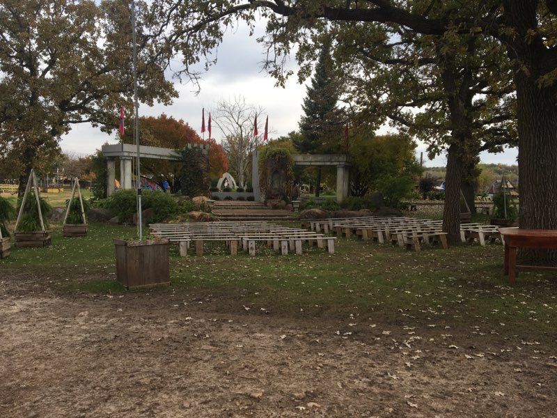 A row of wooden benches are lined up in a field.
