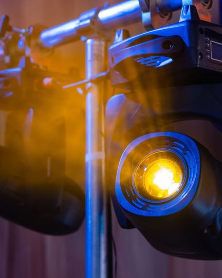 A close up of a stage light with a yellow light coming out of it A close up of a stage light with a yellow light coming out of it