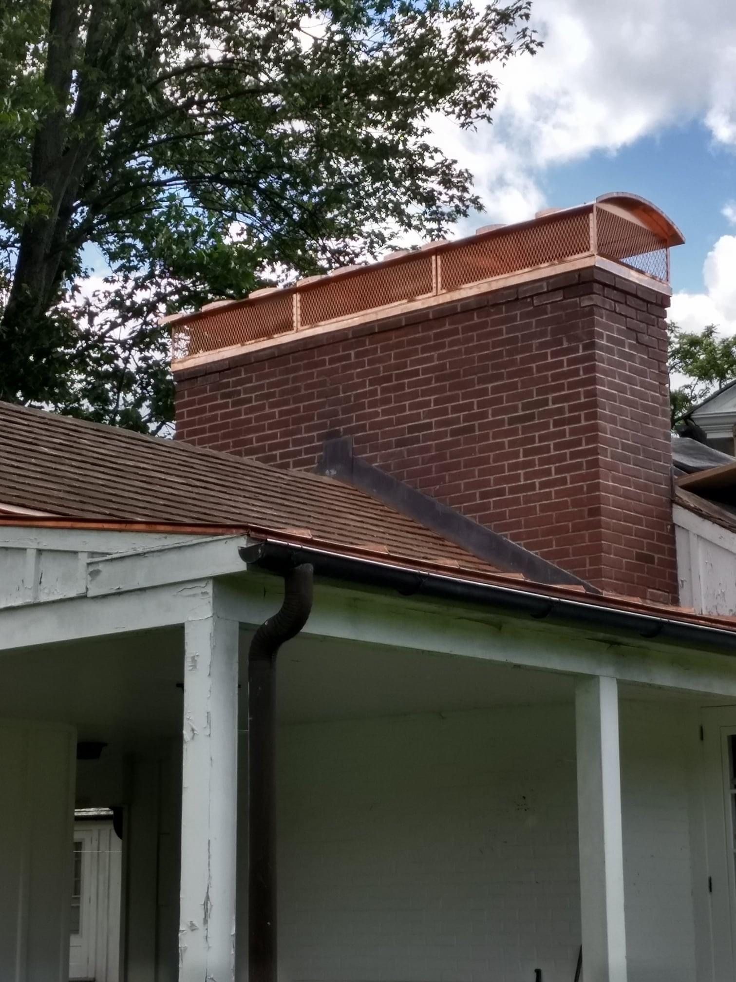 White dormer window on a gray shingled roof with a tall white brick chimney in the background.