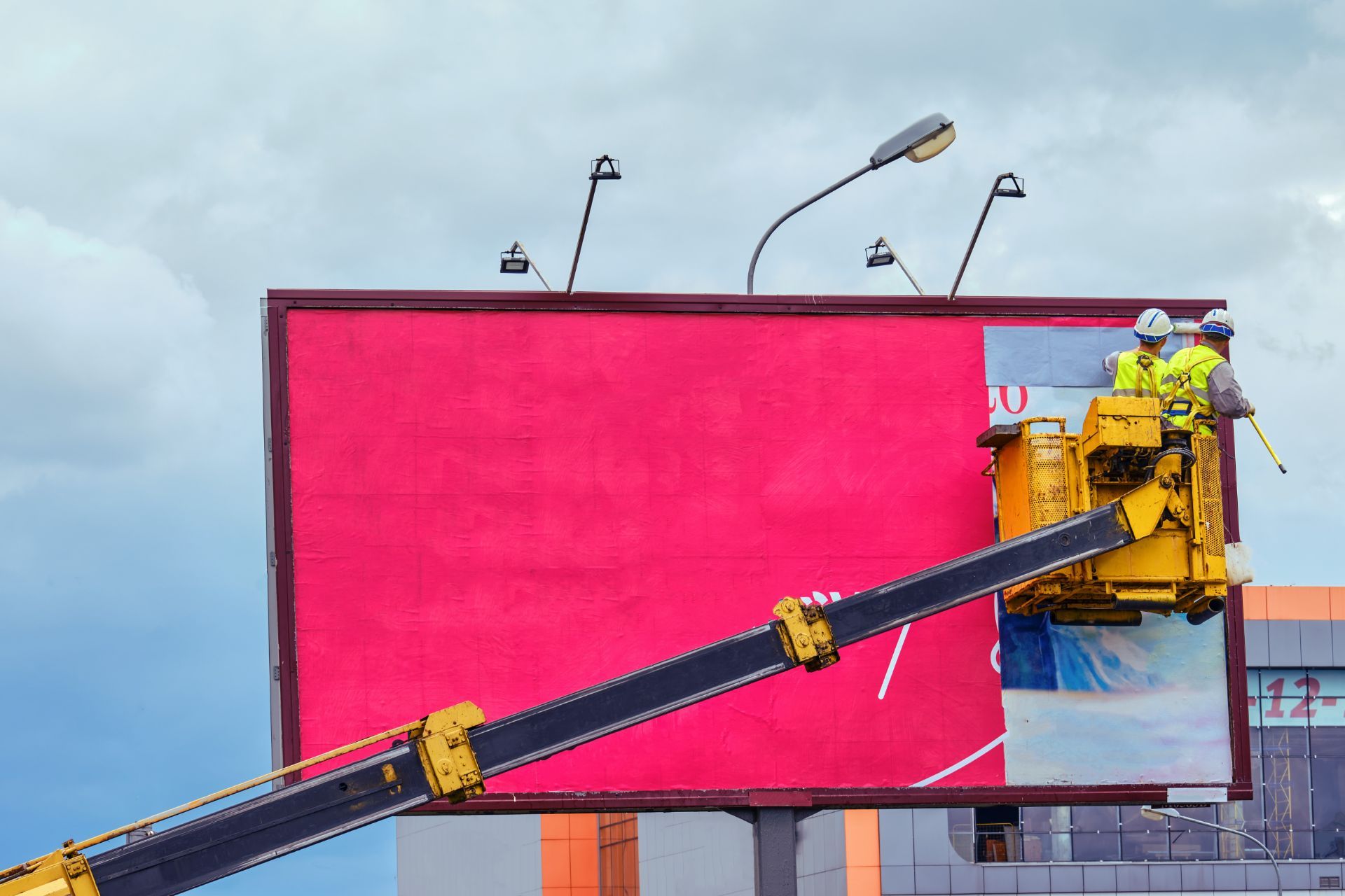 Workers applying art to billboard