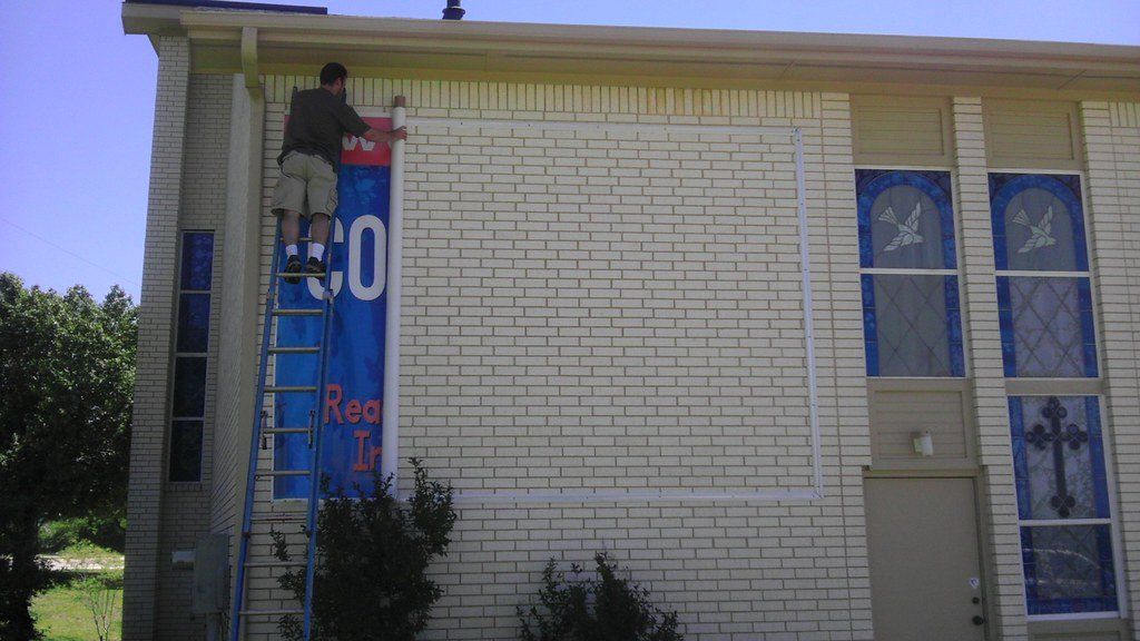 Man rolling out exterior banner