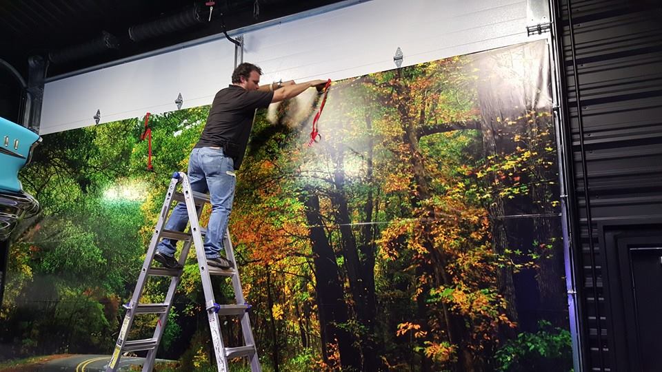 Man installing forest wall photo