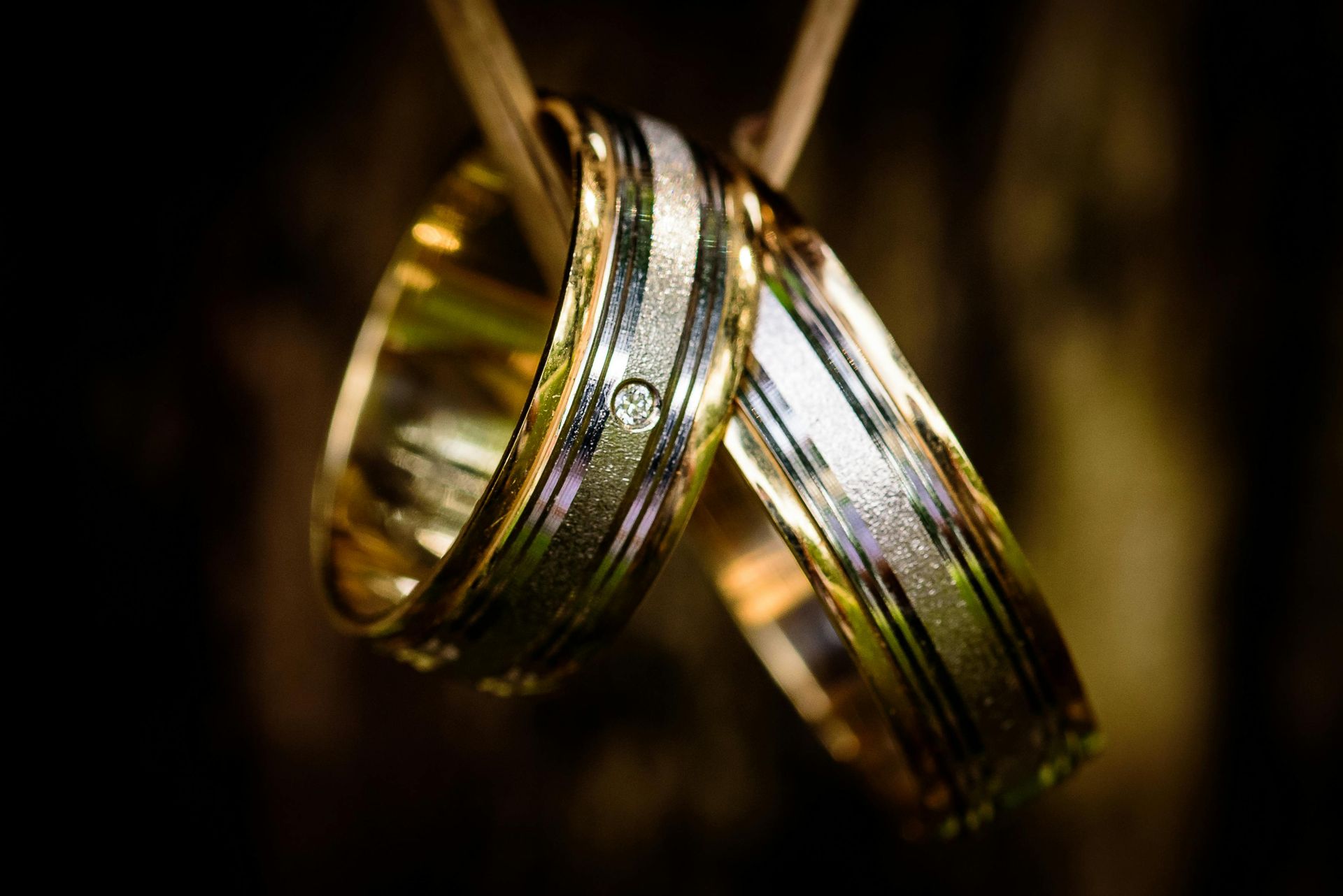 A close up of a diamond ring sitting on top of a wedding band.