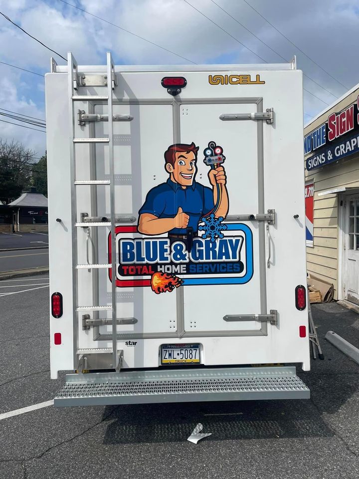 A blue and gray truck is parked in a parking lot
