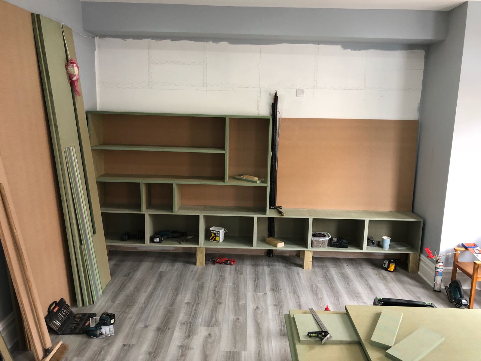 A room with a lot of shelves and a wooden floor.