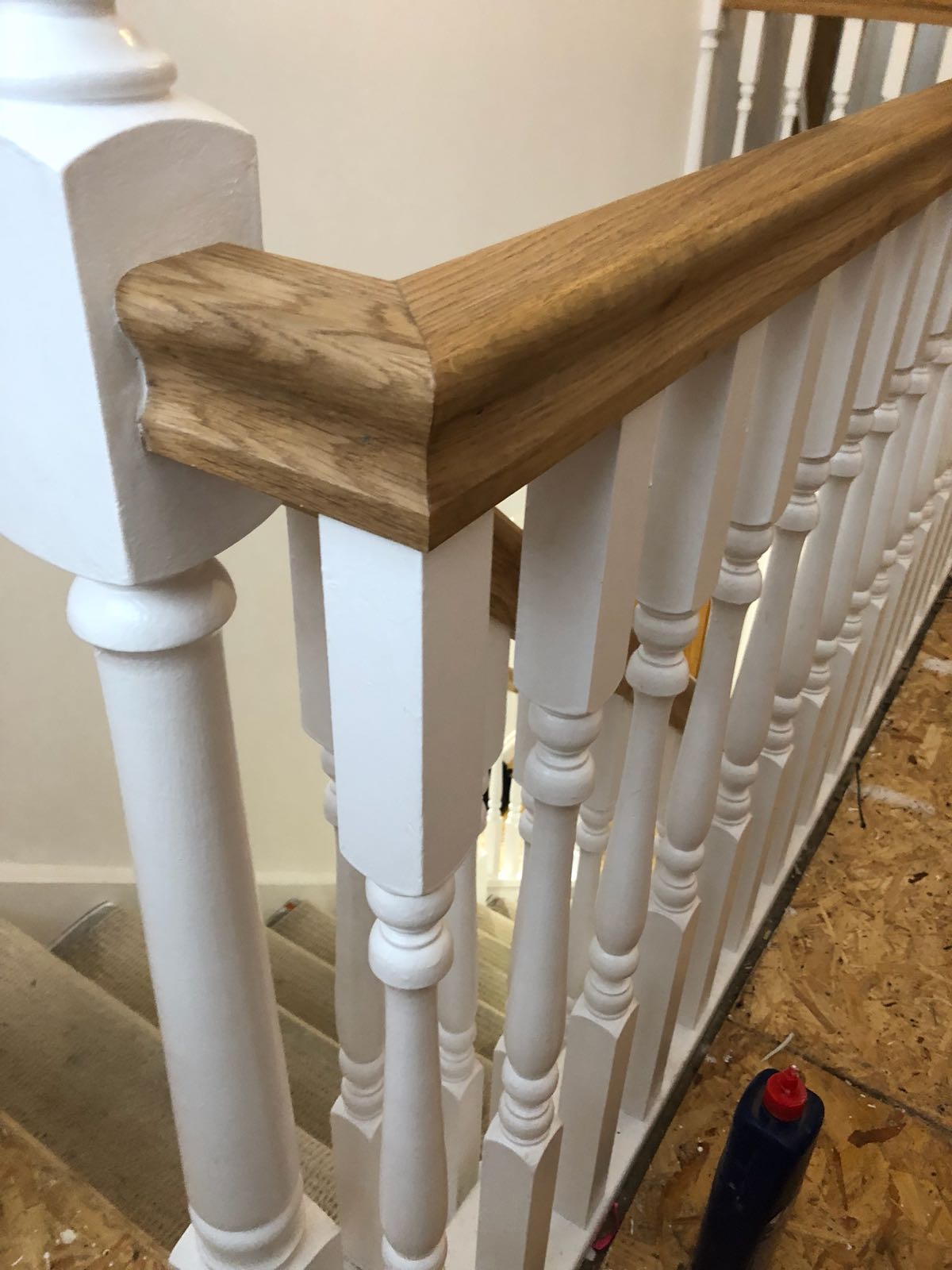 A white railing with a wooden handrail on a staircase.