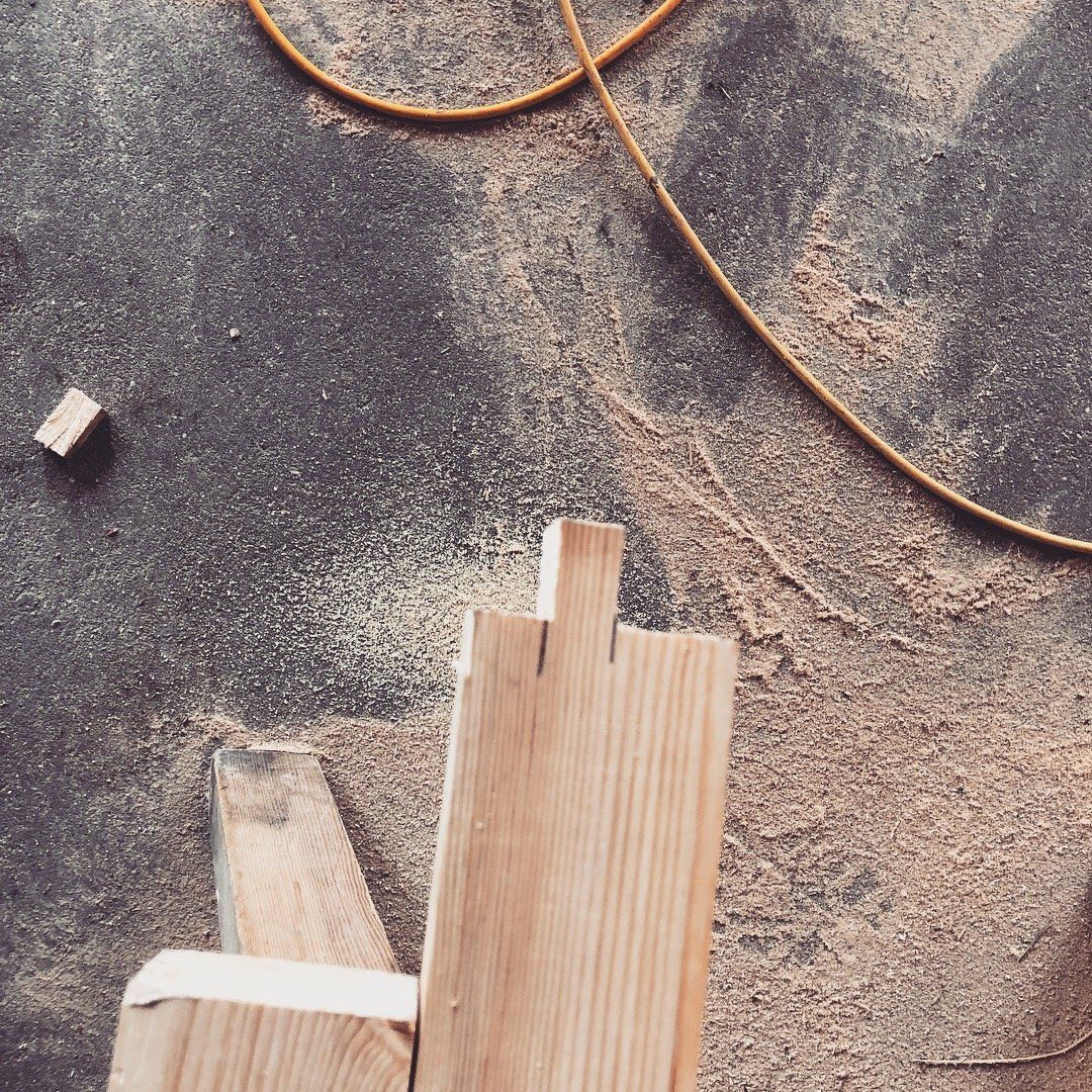 A piece of wood is sitting on a table next to a cord.