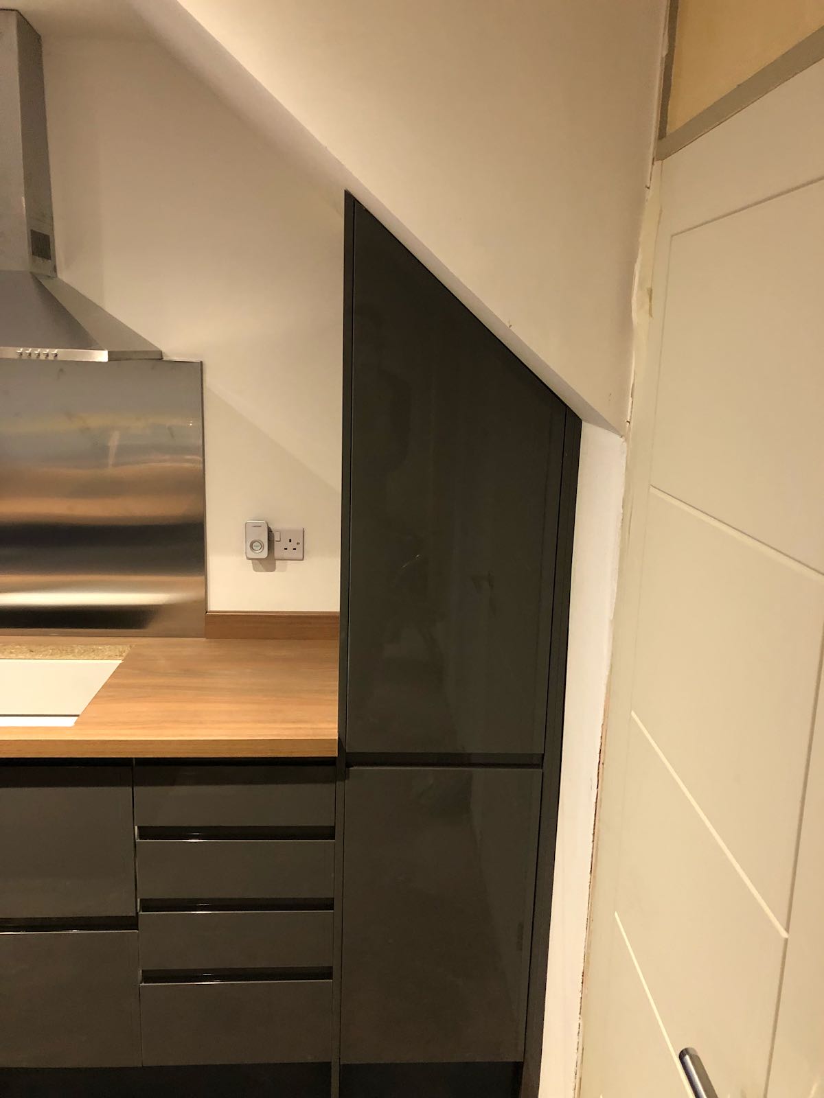 A kitchen with gray cabinets and a wooden counter top