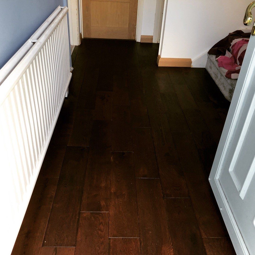 A hallway with hardwood floors and a white radiator