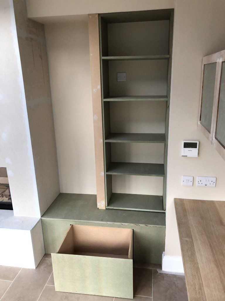 A room with a shelf and a box underneath it