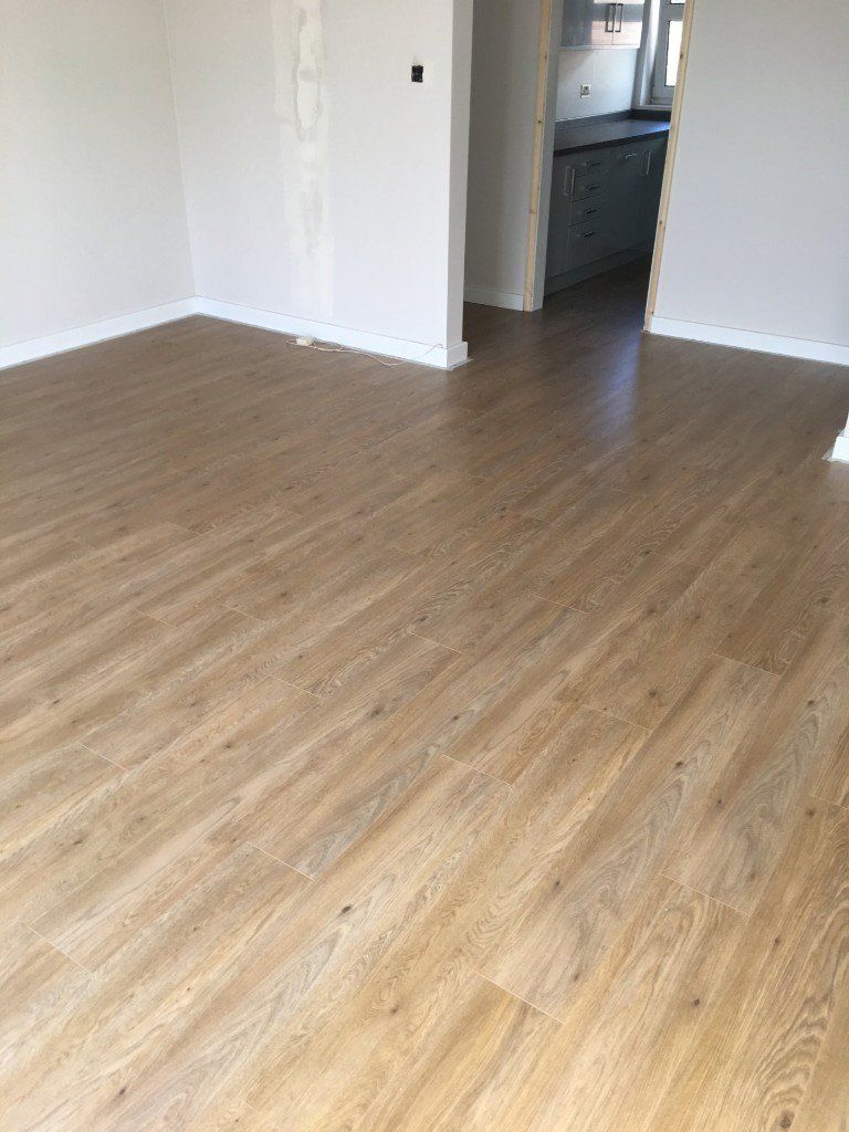 A living room with a wooden floor and white walls.