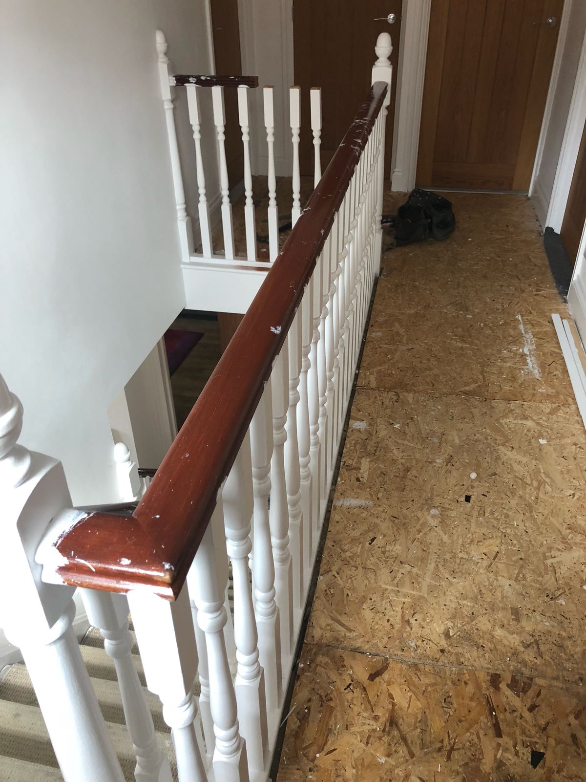 A staircase with white railings and a wooden handrail in a hallway.