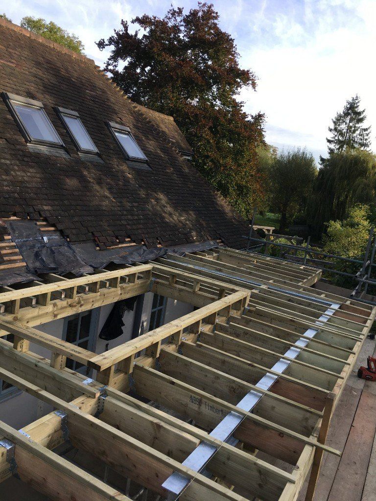 The roof of a house is being built with wooden beams.