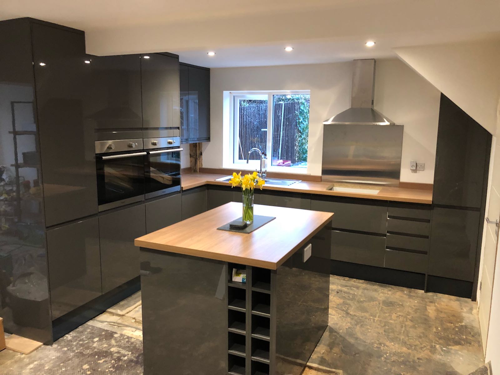 A kitchen with a large island and a vase of flowers on the counter.