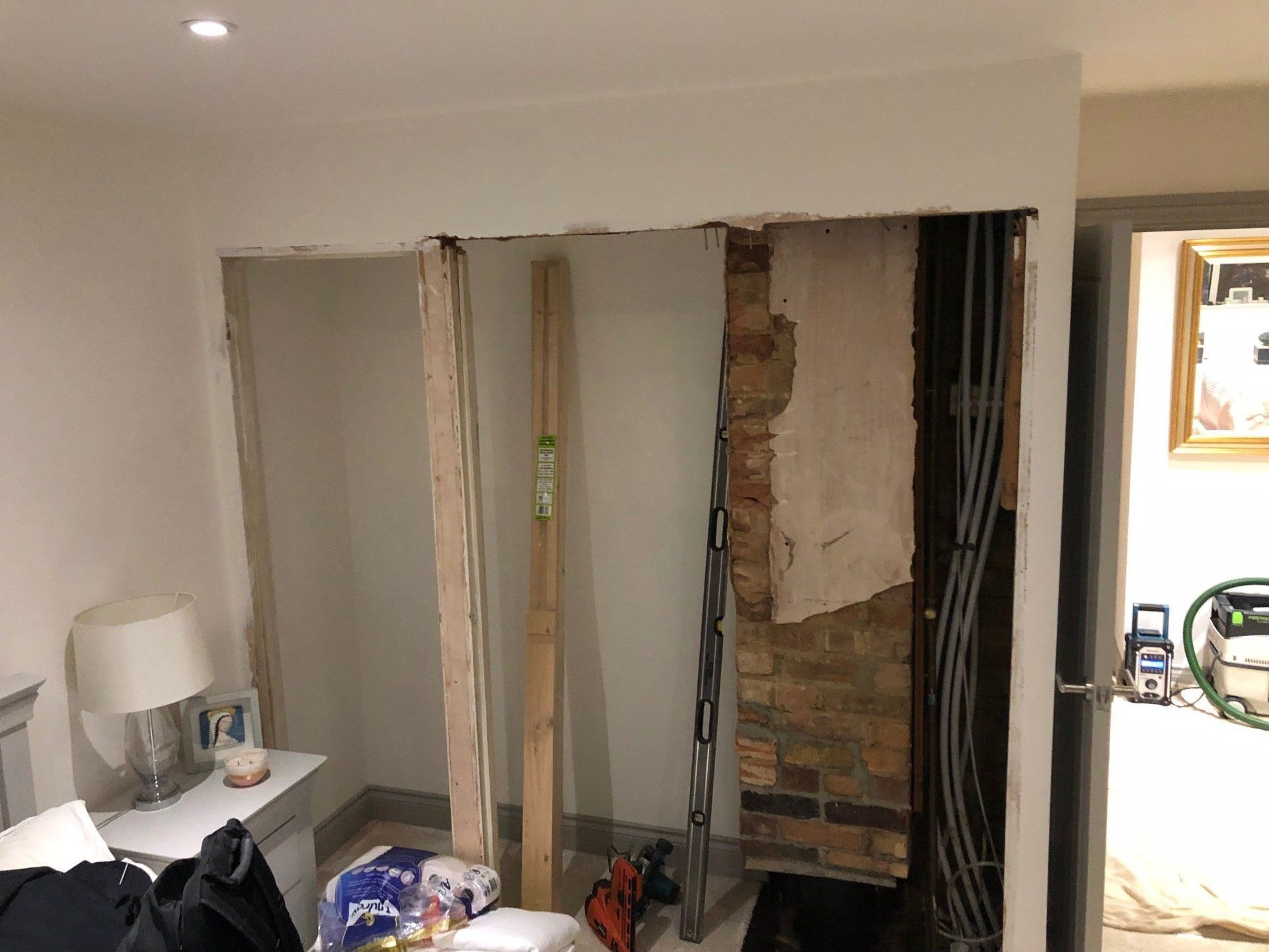 A room with a hole in the wall and a brick wall behind it.