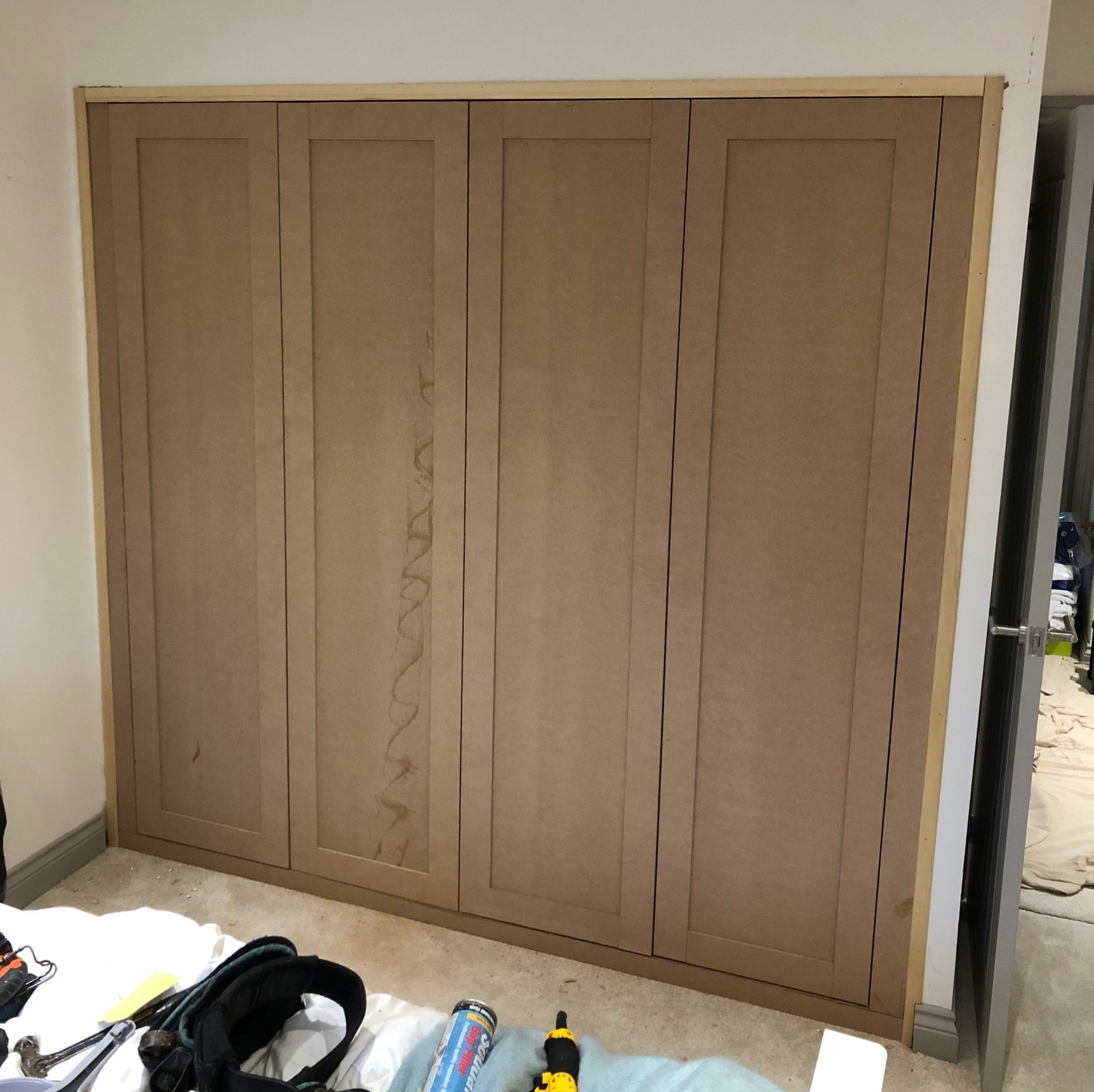 A bedroom with a large wooden wardrobe and a bed.