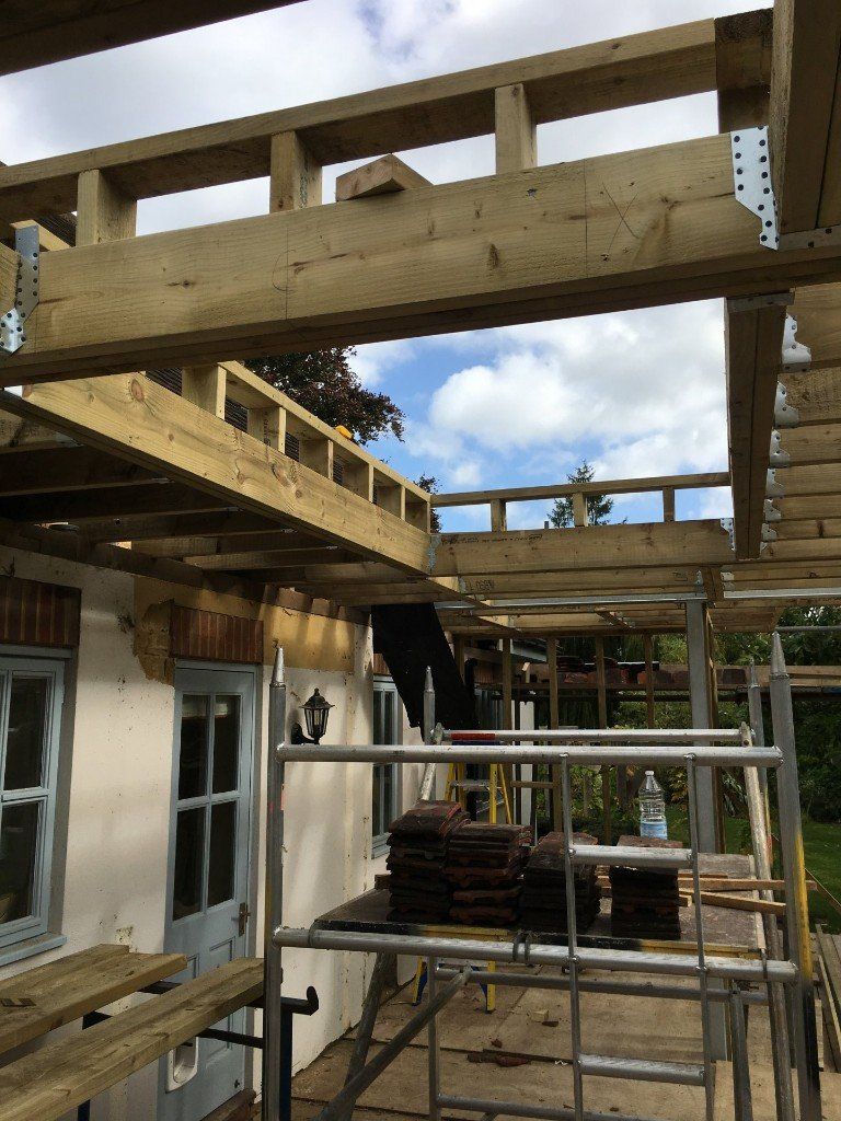A wooden structure is being built on top of a house.