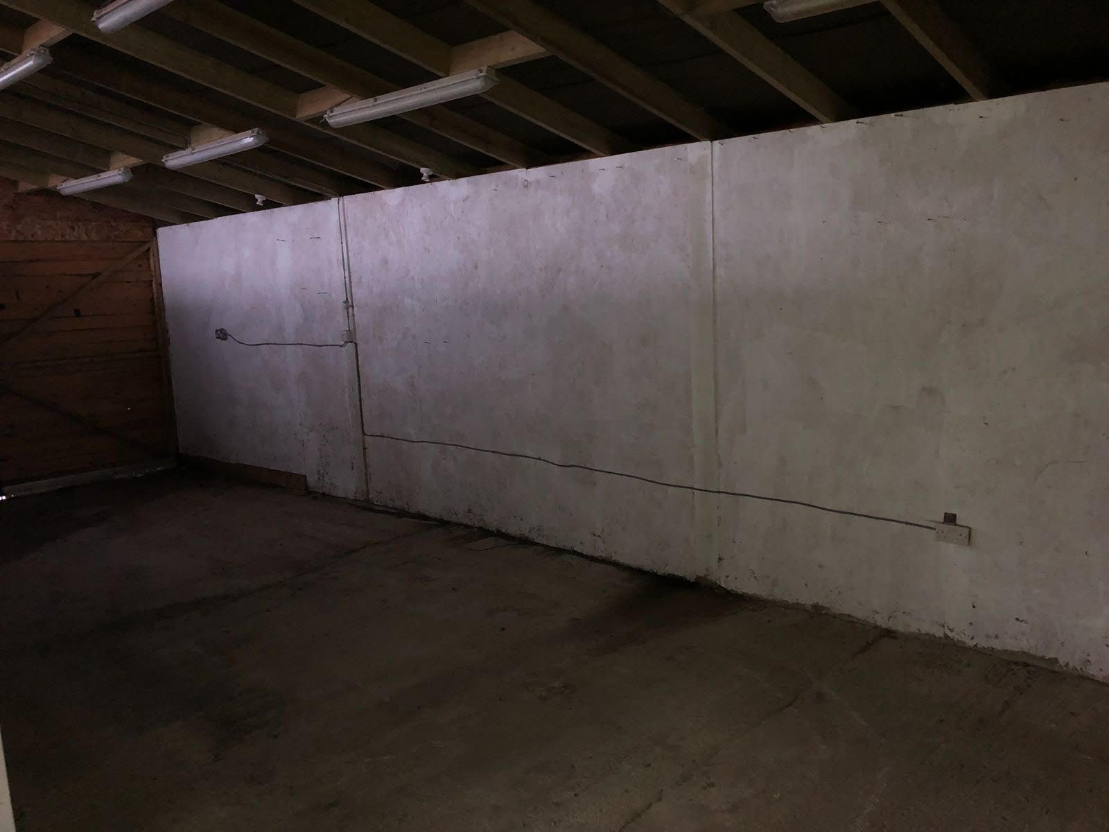 An empty room with a brick wall and a white wall