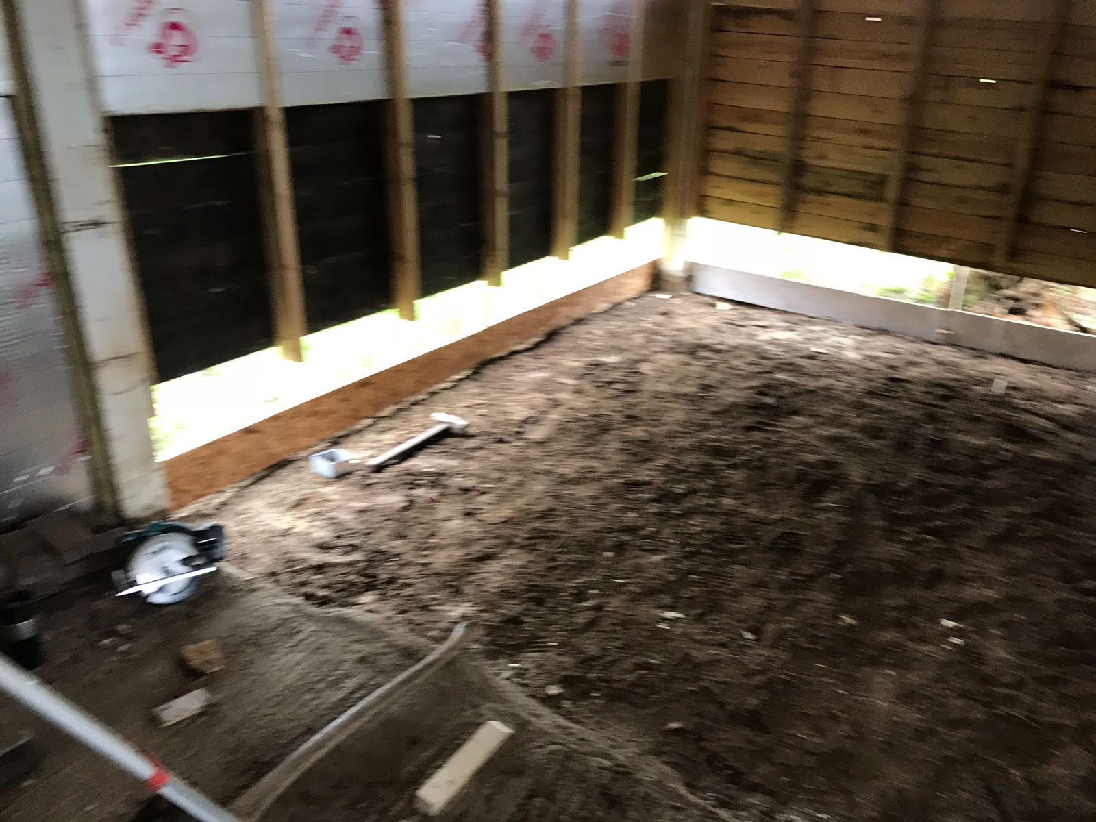 A room with a lot of dirt and a shovel in it