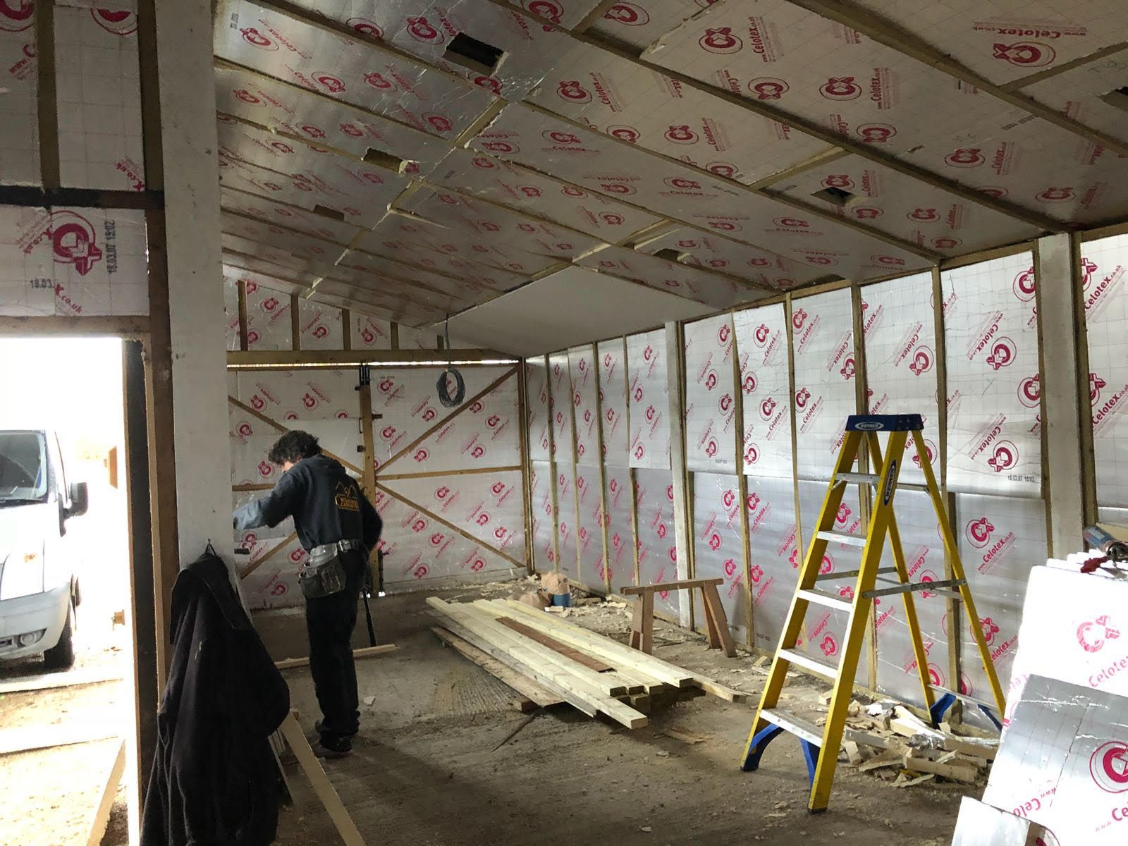 A man is standing in a room with a ladder in it.