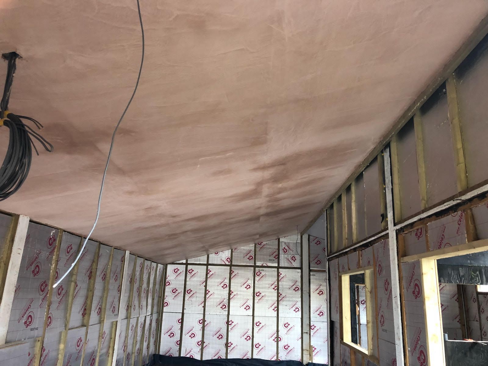 A room with a wooden ceiling and a couch in it.