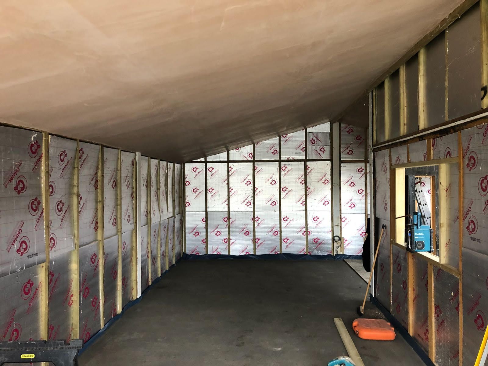 A large room with a lot of windows and insulation on the walls.