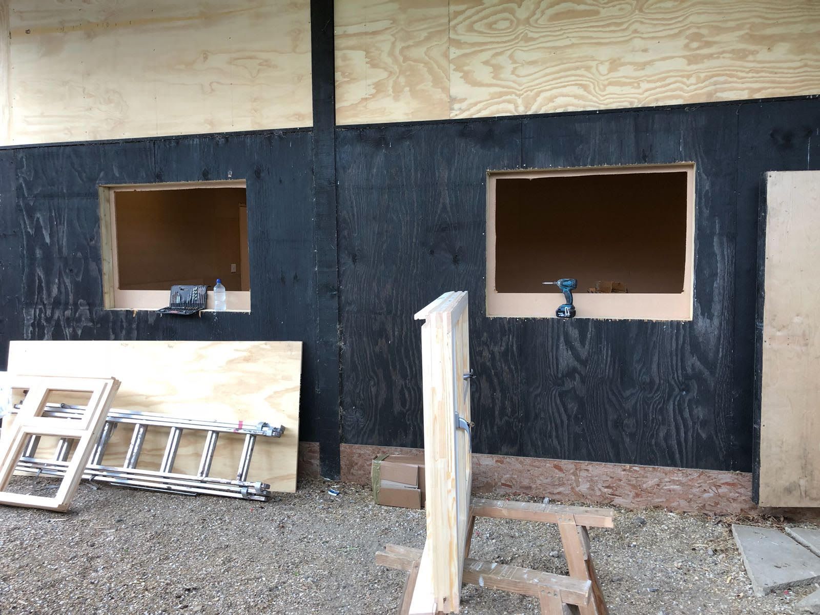 A ladder is sitting in front of a building under construction