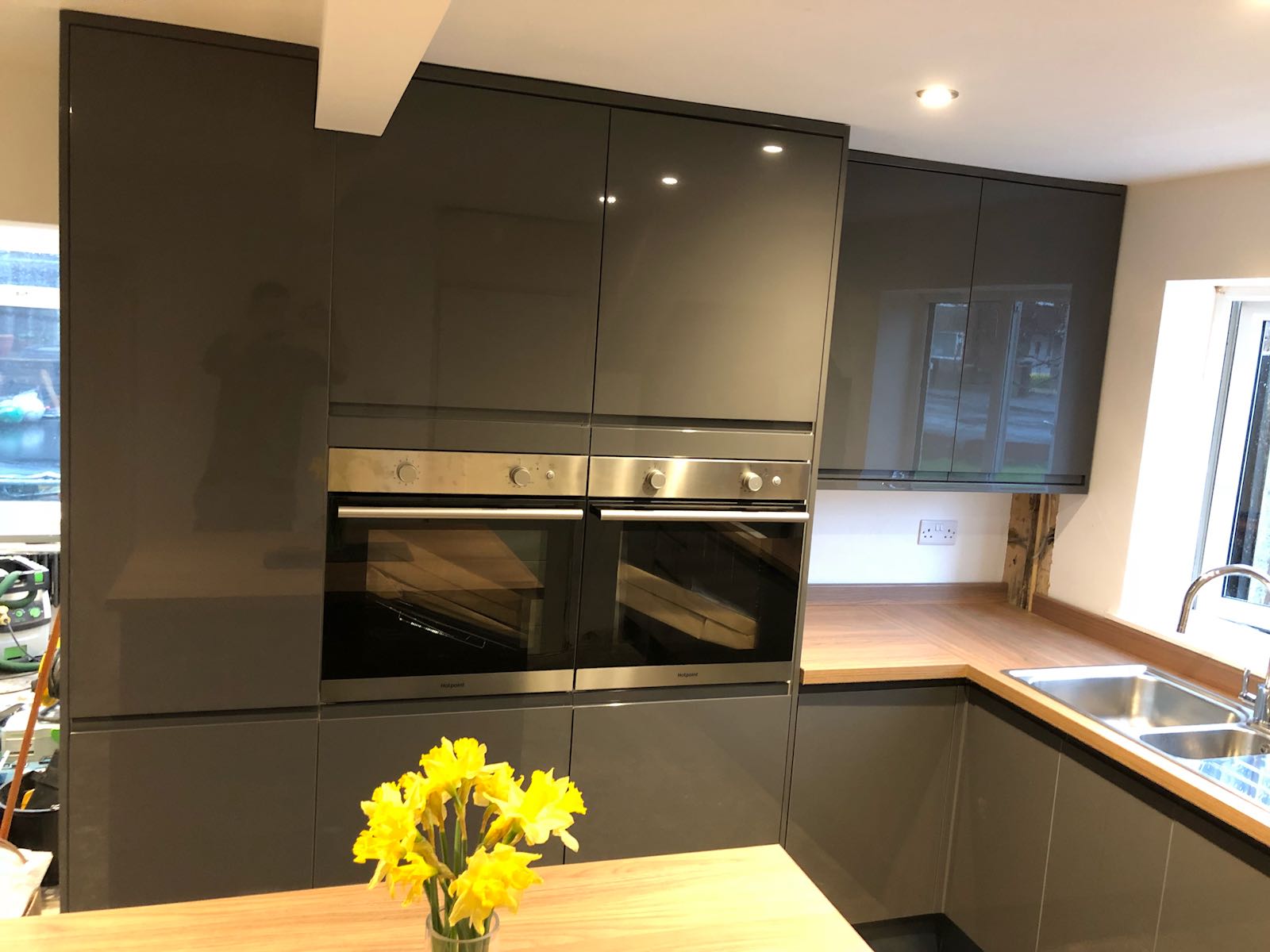 A kitchen with a vase of yellow flowers on the counter.