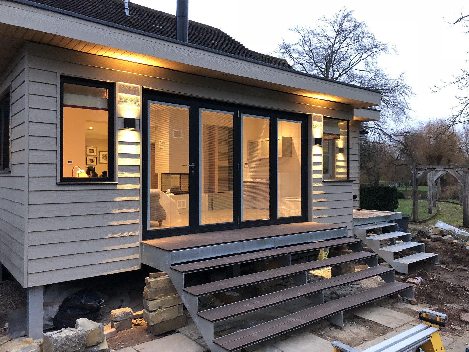 A house with stairs leading up to it and a lot of windows.