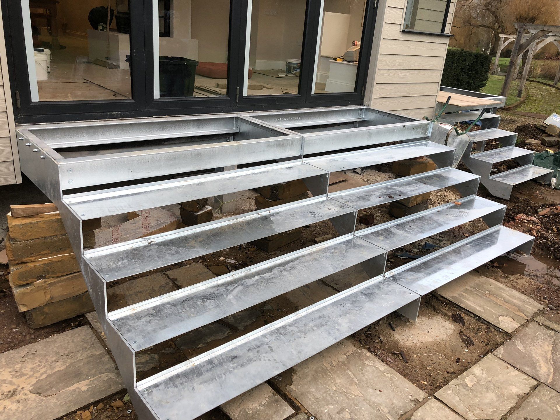A metal staircase is being built in front of a house.