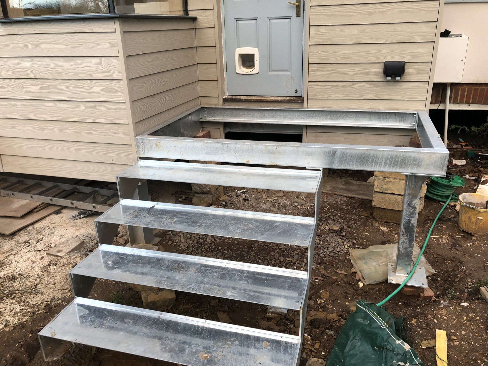 A metal staircase is being built in front of a house.