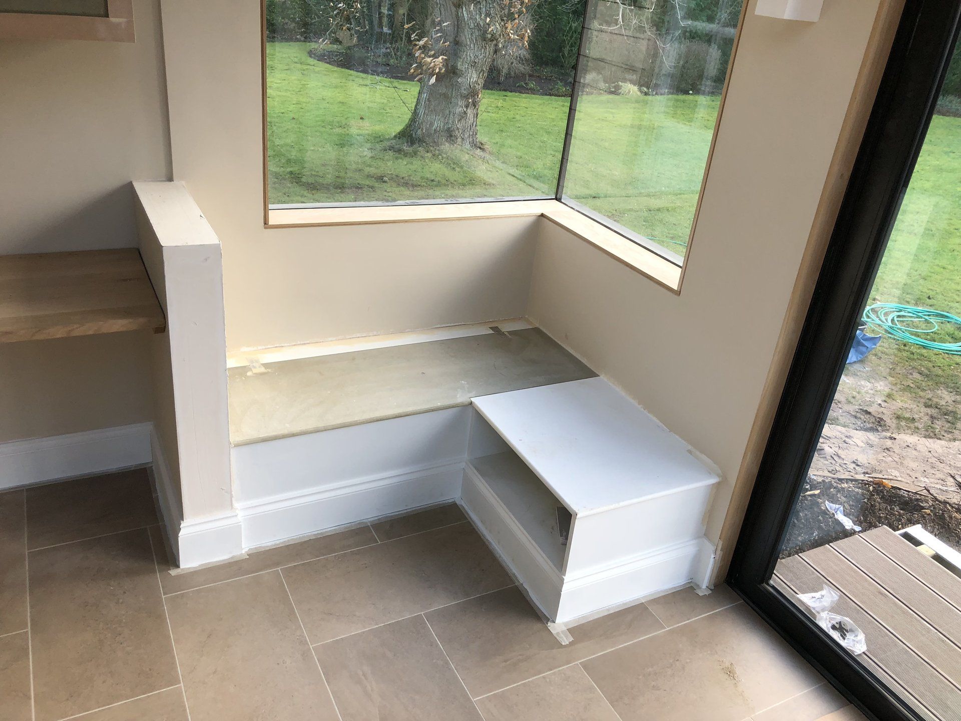 There is a window seat in the corner of the room.