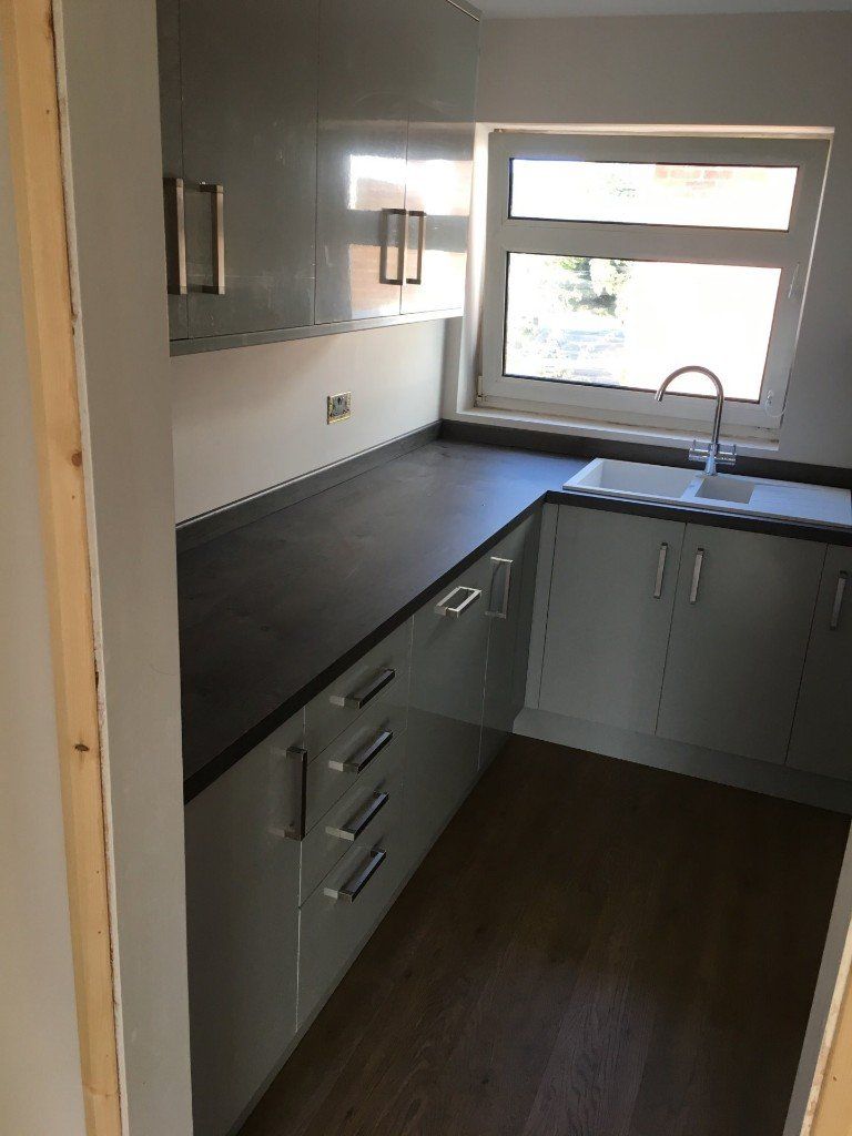 A kitchen with white cabinets and a sink and a window
