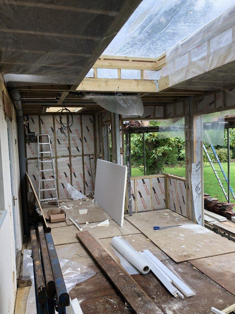 A room under construction with a ladder and a lot of wood.
