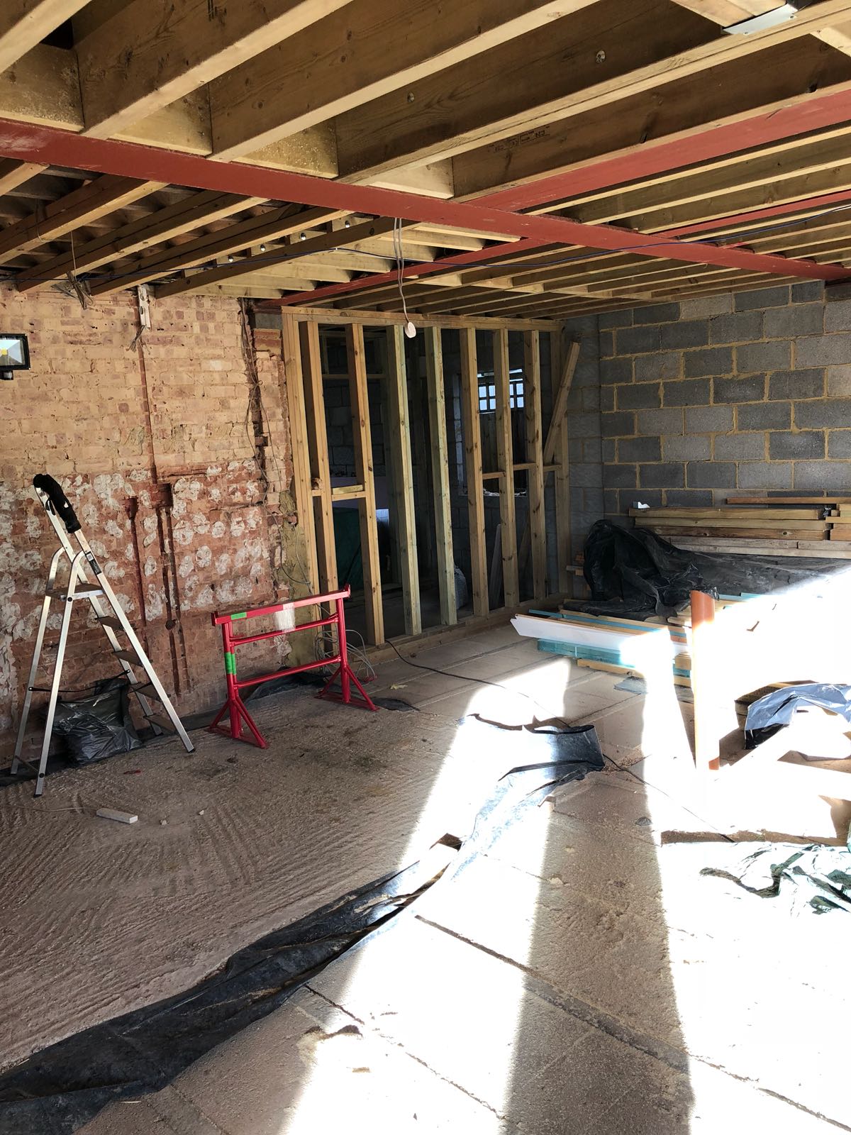 A room under construction with a ladder and a ladder on the floor.