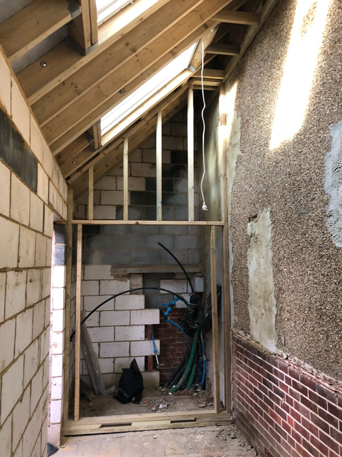 A room with a brick wall and a wooden ceiling is being built.