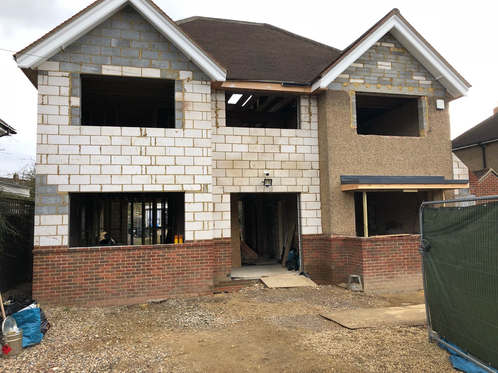 A house is being built with bricks and a brown roof.