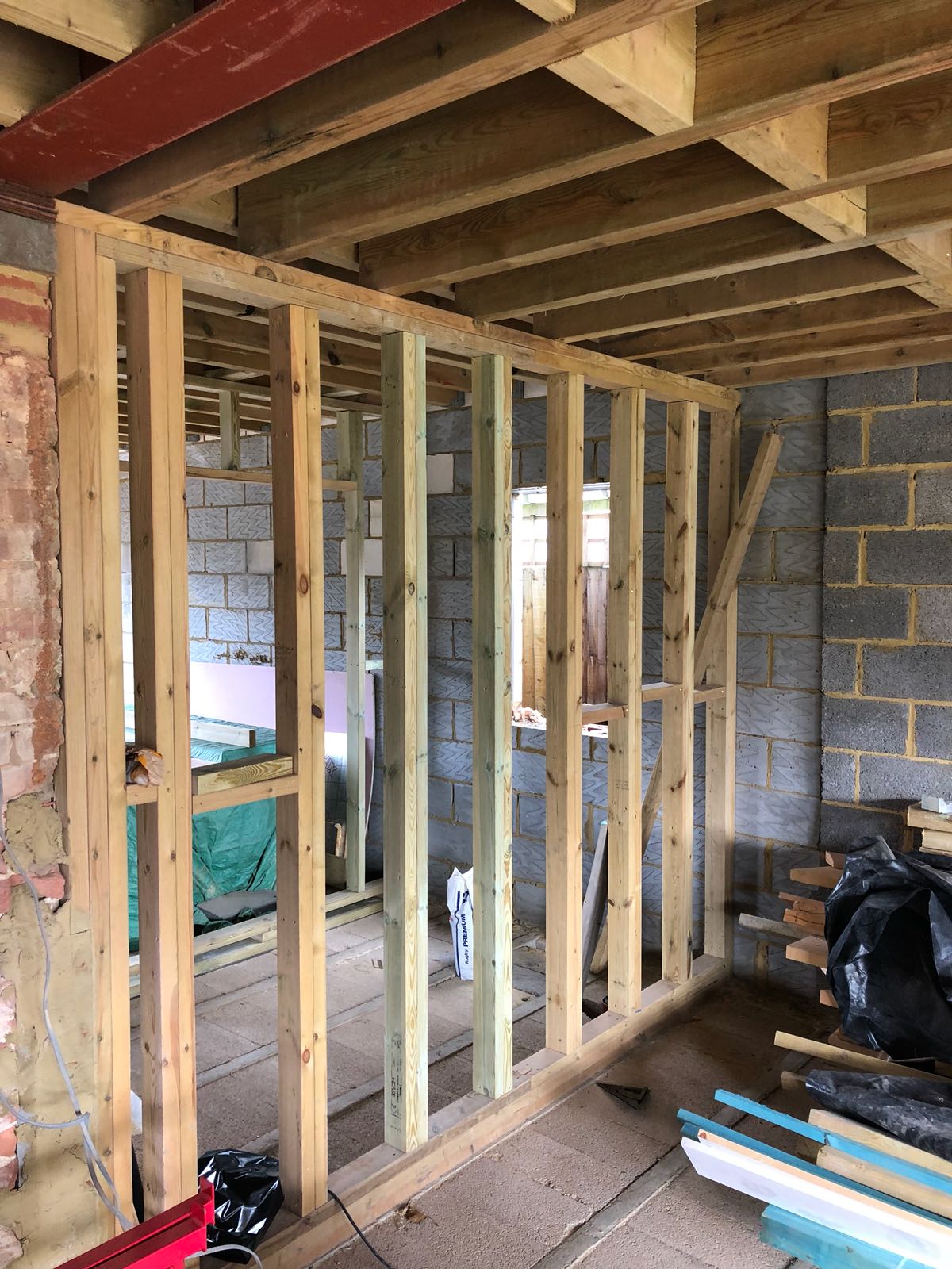 A room is being built with wooden beams and bricks.