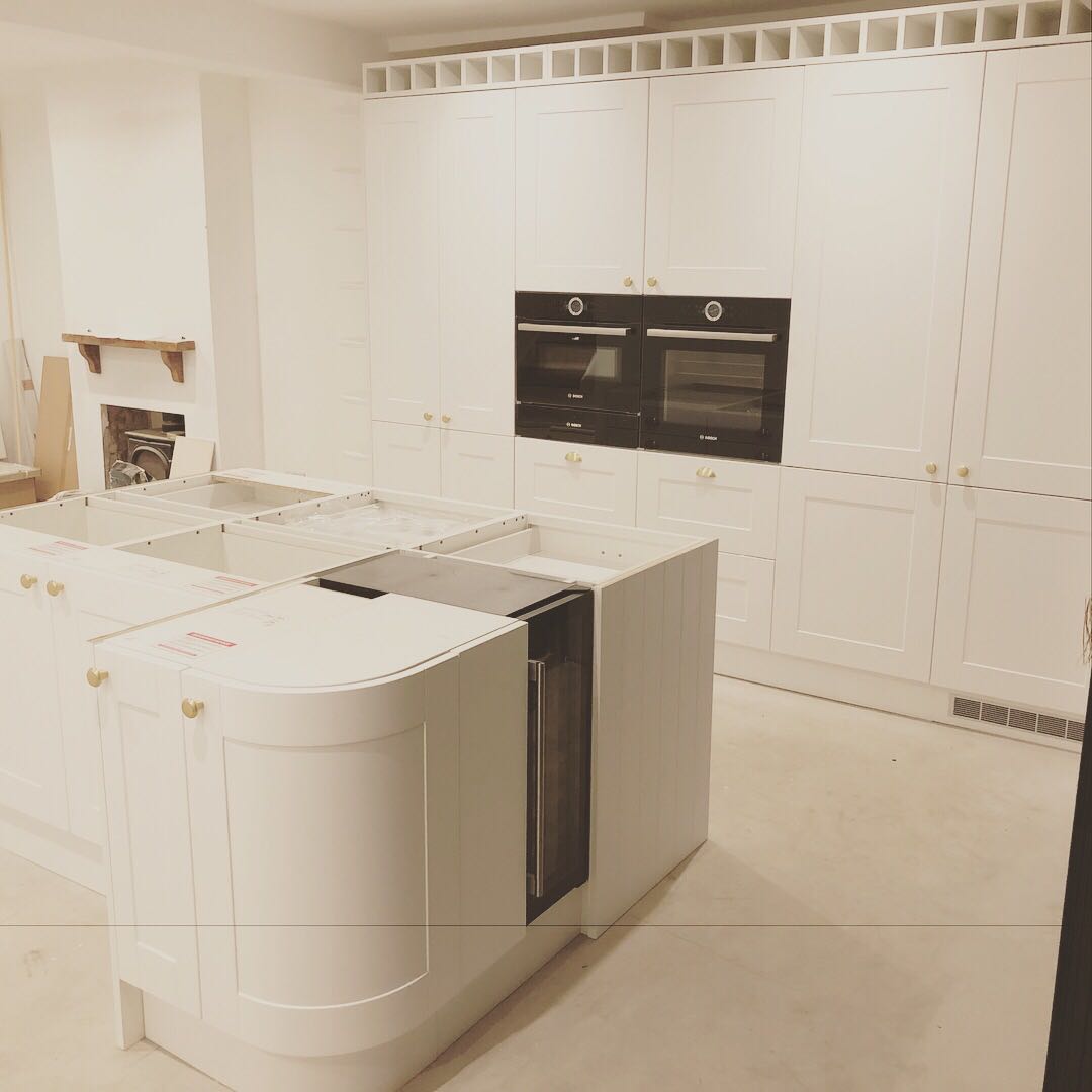 A kitchen with white cabinets and black appliances