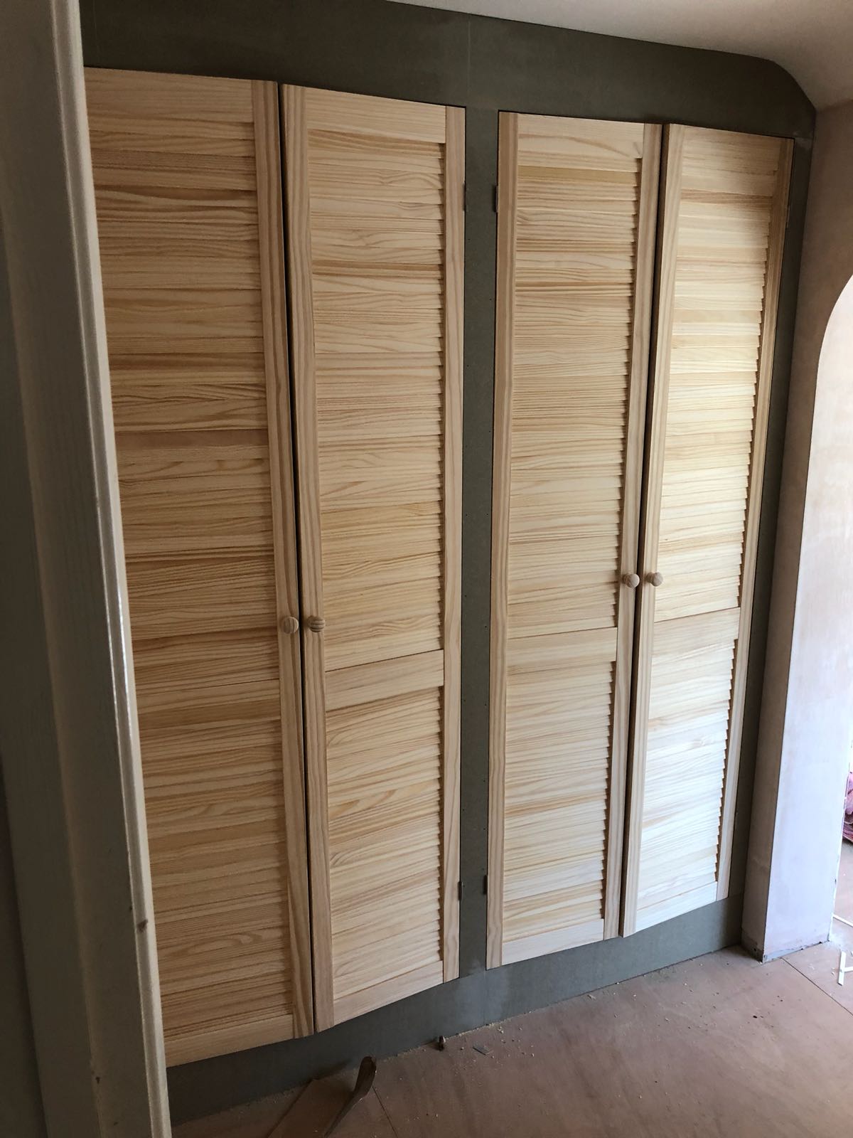 A room with a lot of wooden doors on the wall.